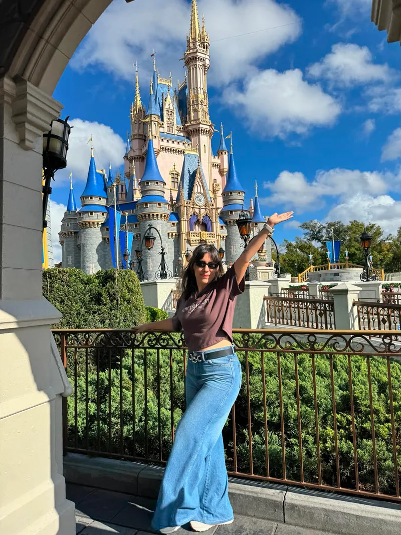 Ani frente al castillo de Disney con los brazos abiertos